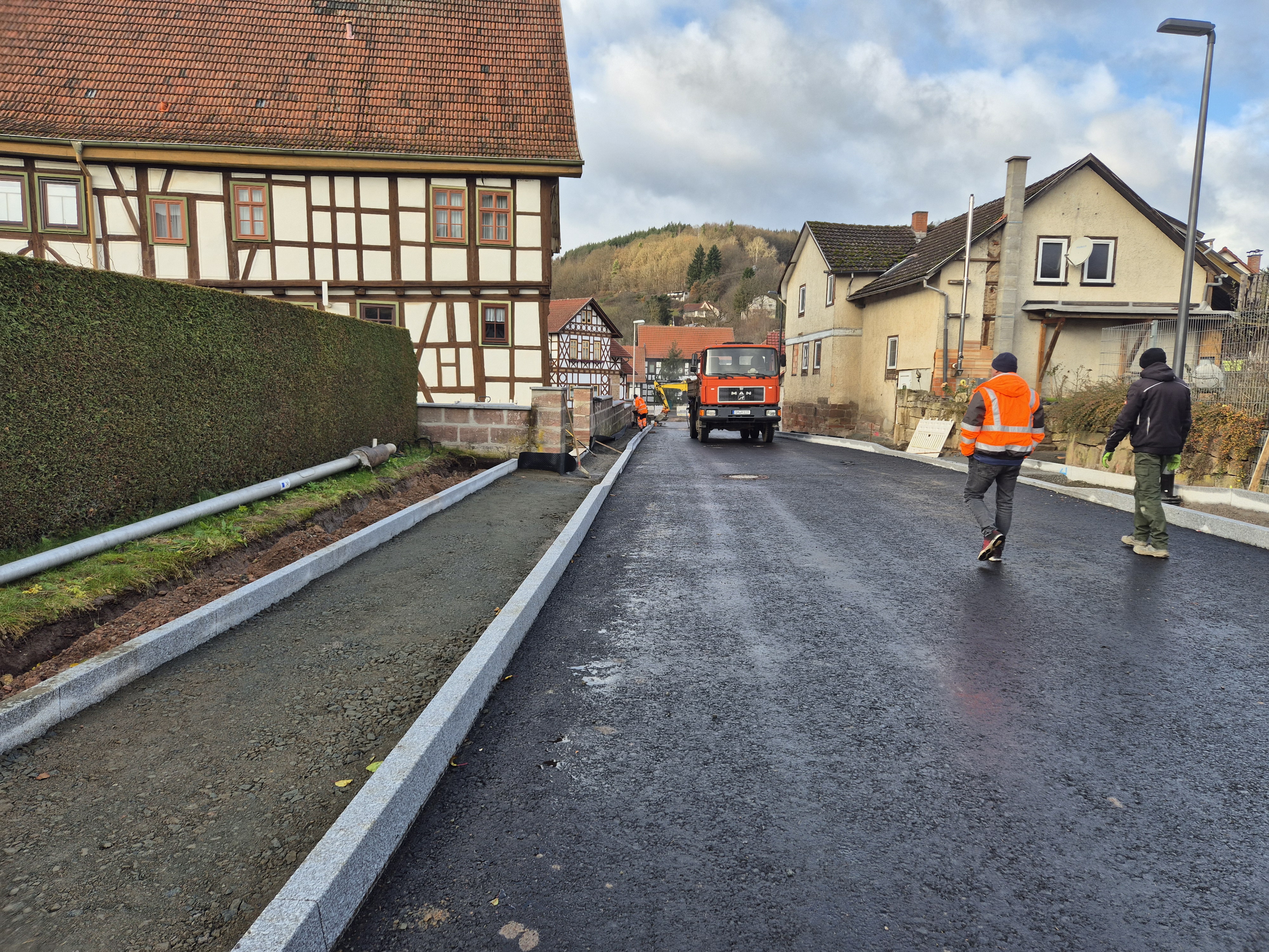 Asphaltierte Straße links und rechts Bordsteine gesetzt